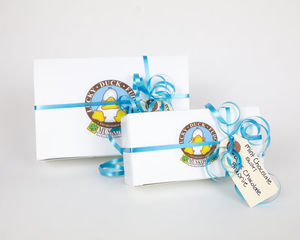 2 gift wrapped boxes of Lucky Duck Fudge: 1 large box, and a small box in front. Both set on a white background. 
